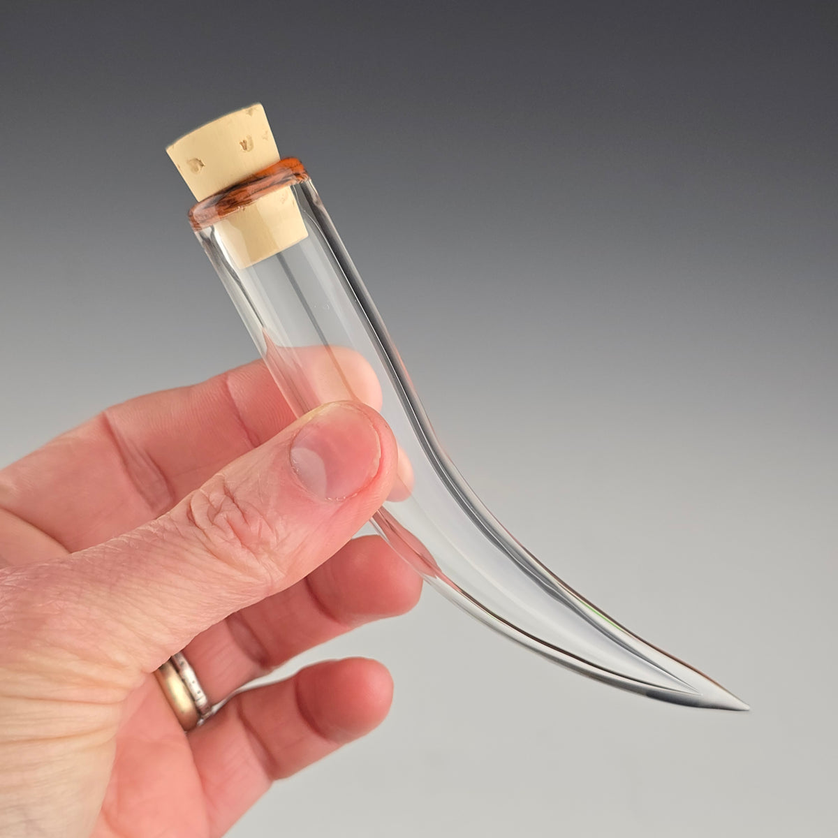 Keep the fallen whiskers you find safe inside this small hand blown whisker shaped jar made out of clear glass with a tortie color accent around the corked opening.
