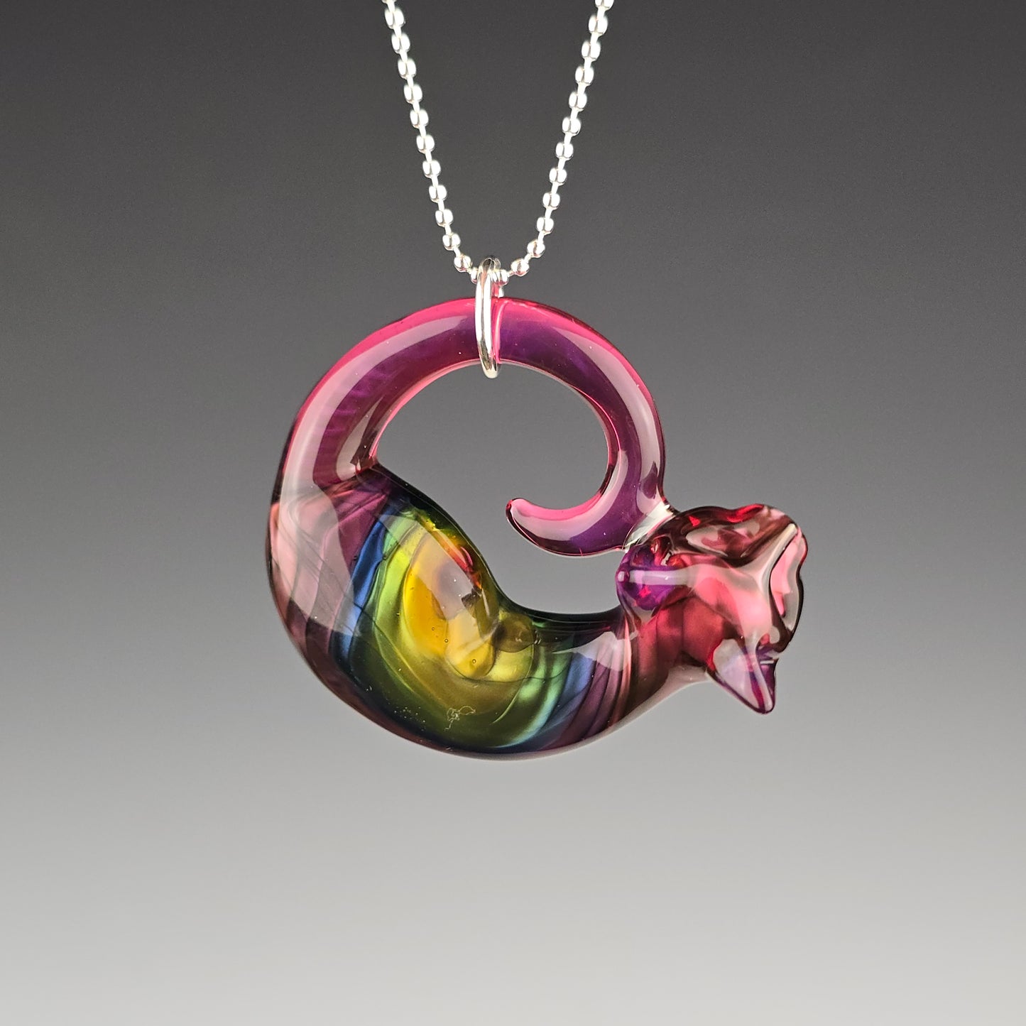 Sleeping kitty glass pendant made with pinks and a metallic rainbow of colors