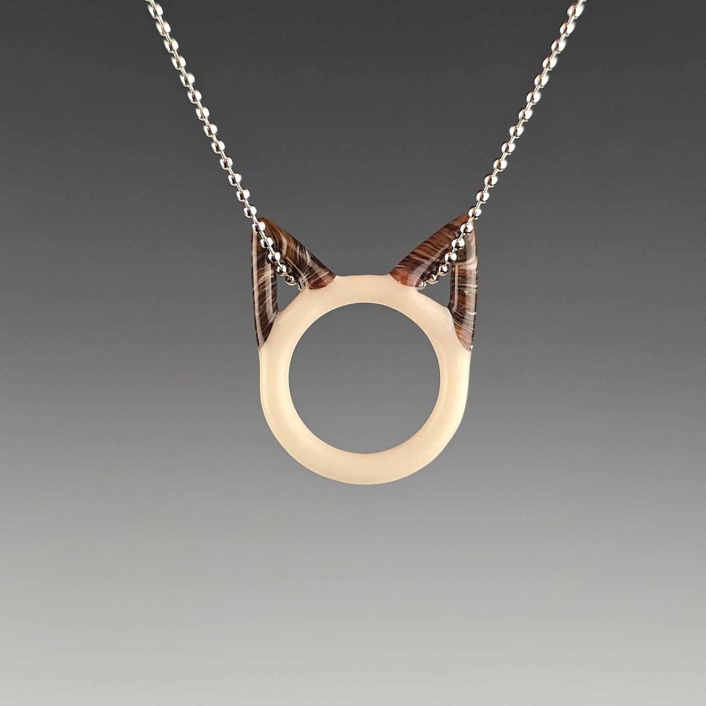 Seal Point siamese glass kitty face necklace hanging on a silver ball chain