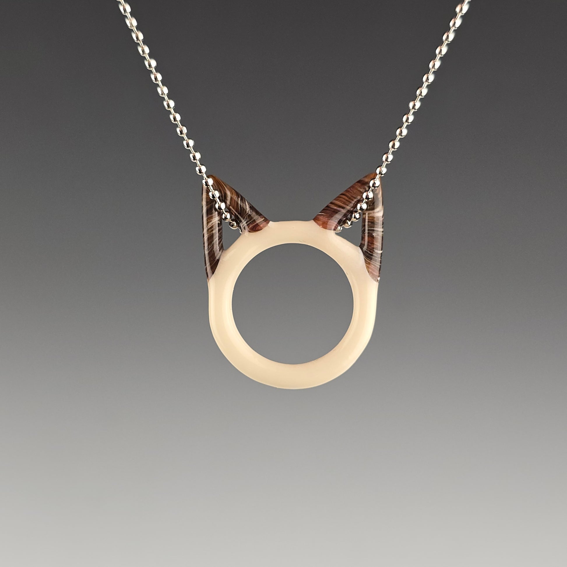 Seal Point siamese glass kitty face necklace hanging on a silver ball chain