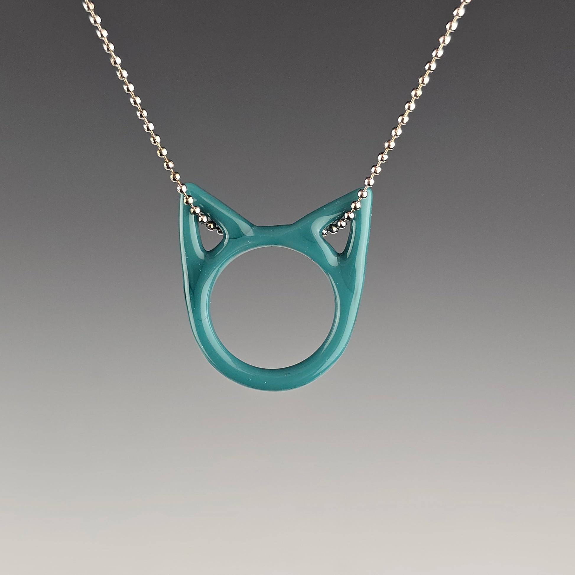 aqua turquoise glass kitty face necklace hanging on a silver ball chain