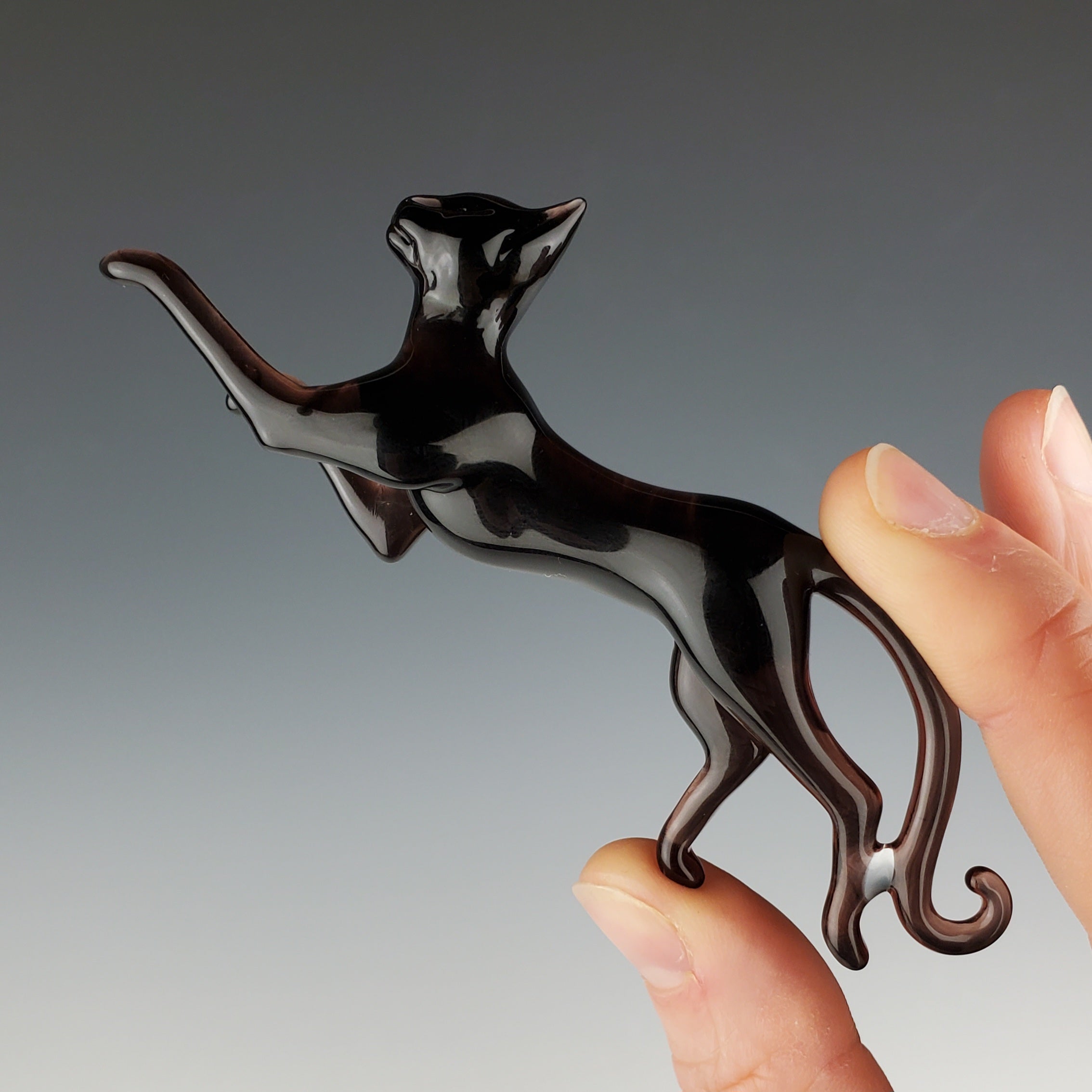 glass sculpture of a cat doing a big stretchy