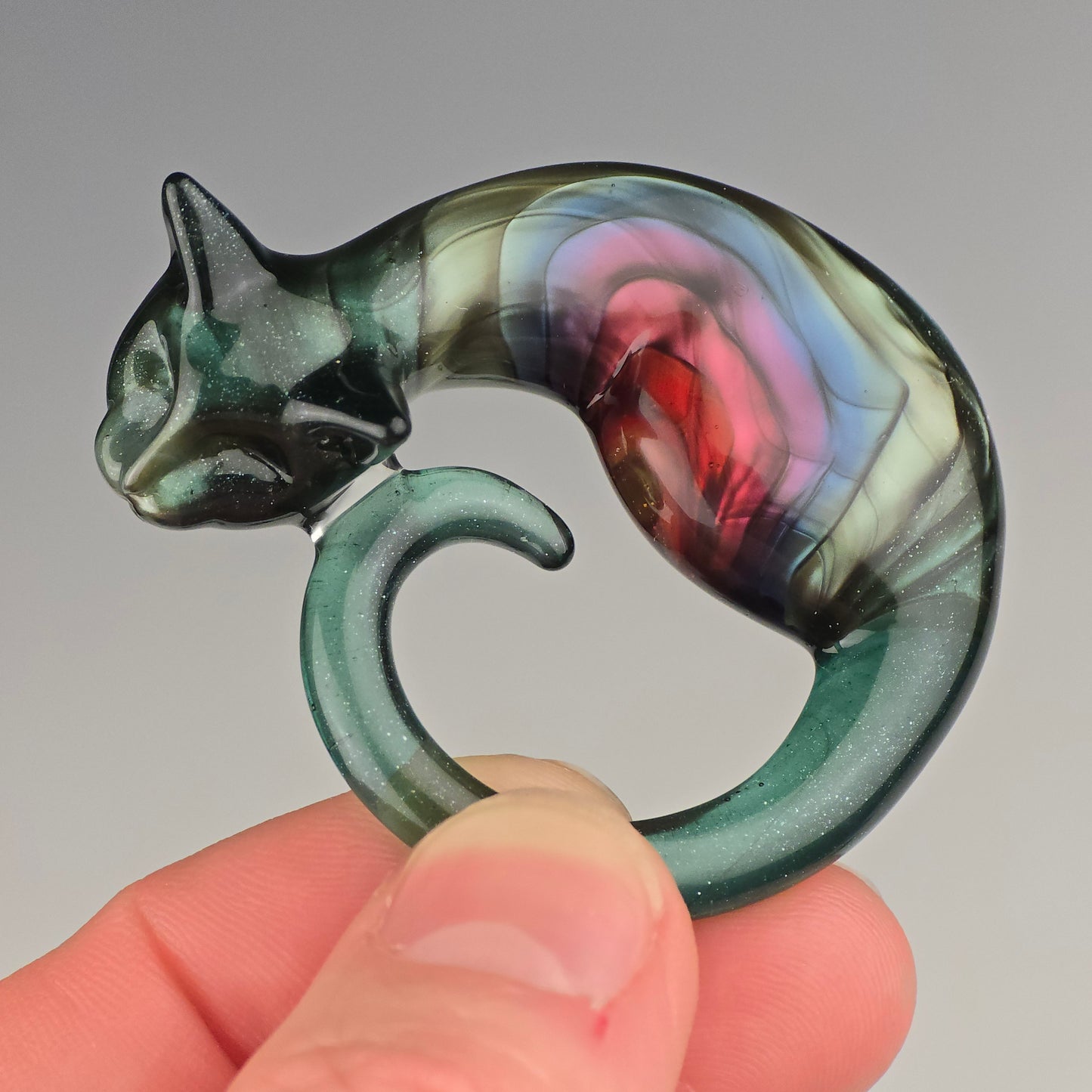 Glass sleeping cat figurine with a colorful metallic rainbow