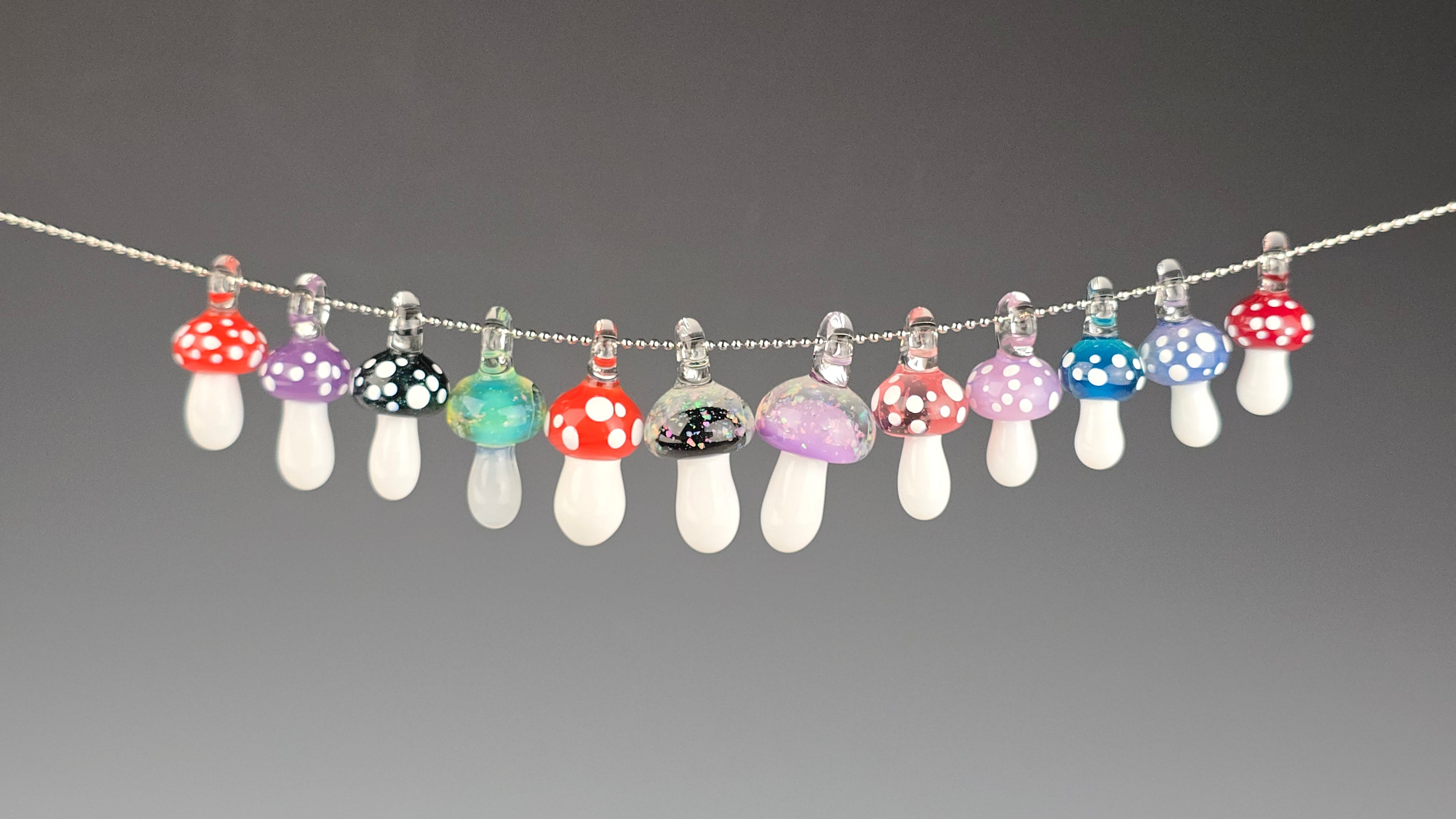 String of colorful mushroom-shaped beads on a gray background