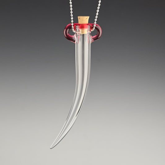 Keep the fallen whiskers you find safe inside this small hand blown hanging whisker shaped jar made out of clear glass with a pink tela magenta color accent around the corked opening.