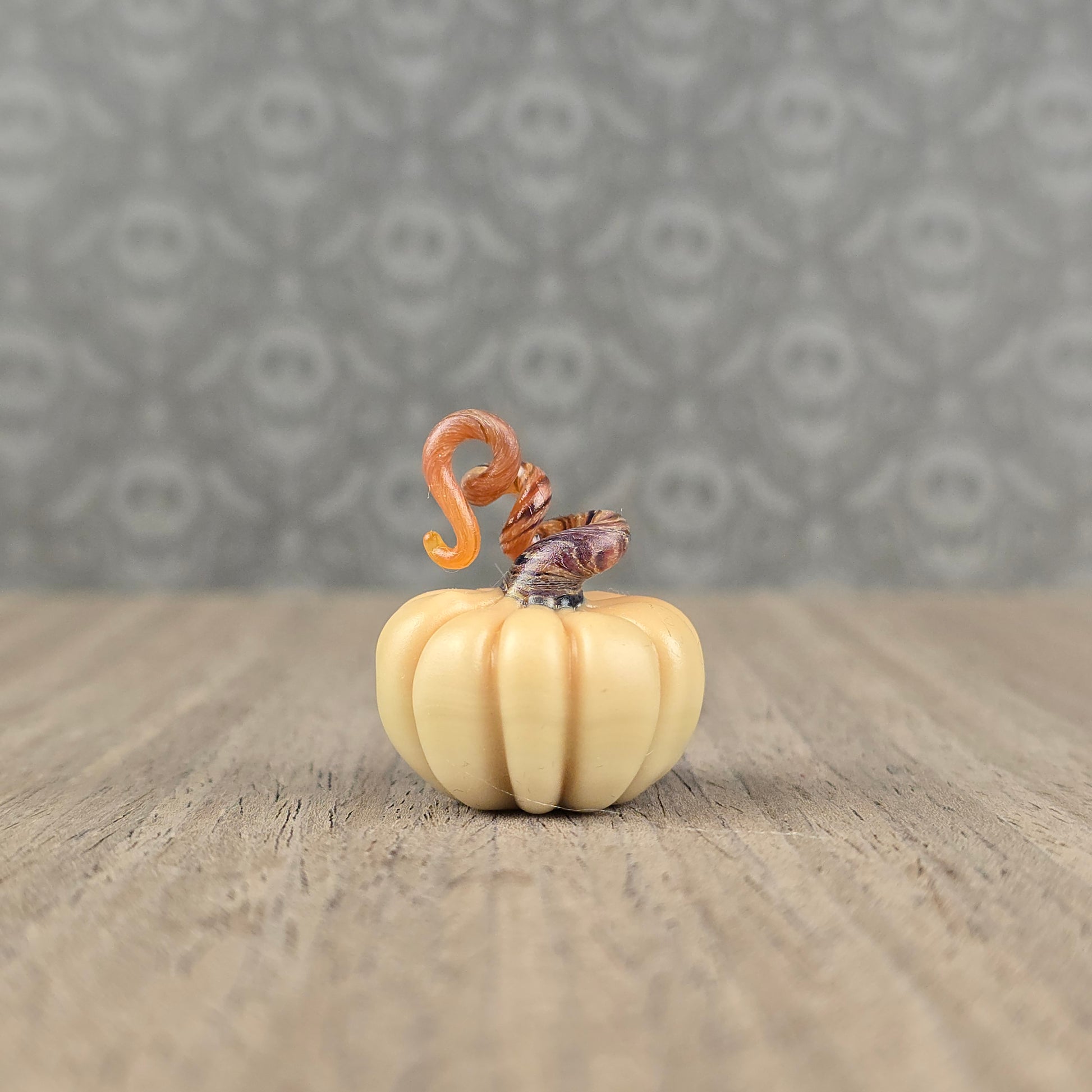 miniature handmade glass pumpkin with twisty dark brown stem