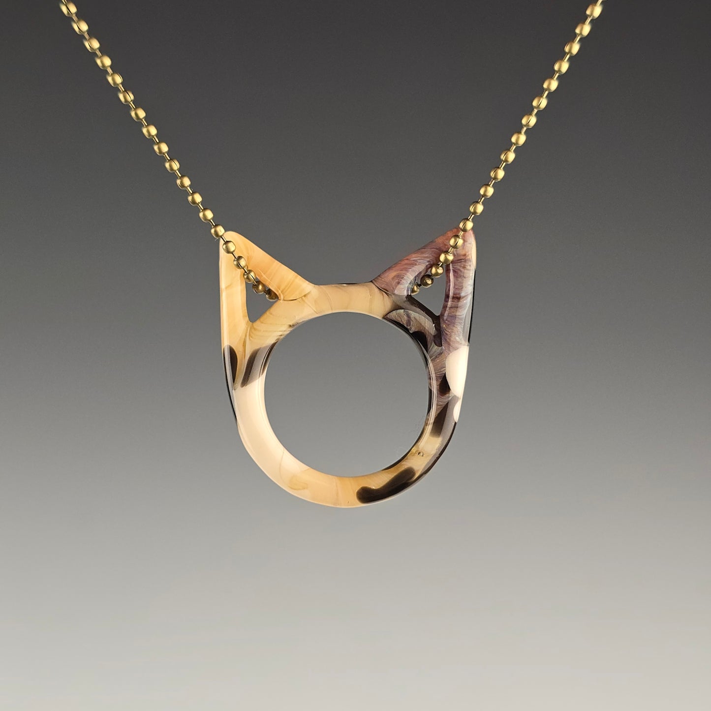Tabbico tabby calico glass kitty face necklace hanging on a brass ball chain