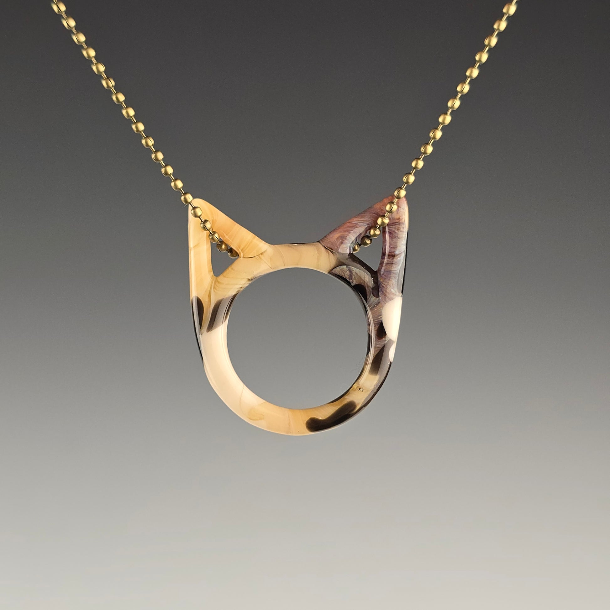 Tabbico tabby calico glass kitty face necklace hanging on a brass ball chain